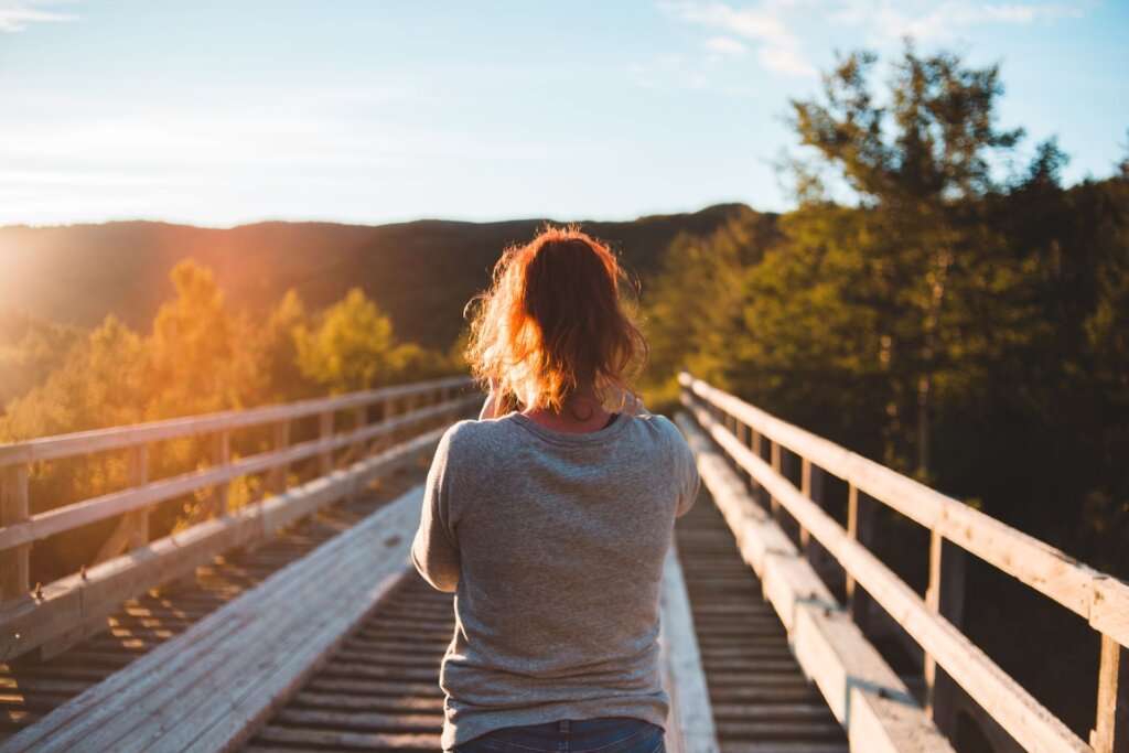 Mujer de espaldas en la naturaleza al amanecer