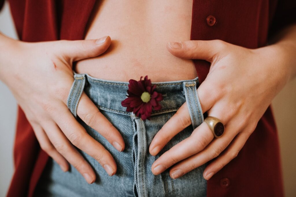 Mujer sujetando su abdomen como símbolo de salud digestiva y bienestar intestinal.