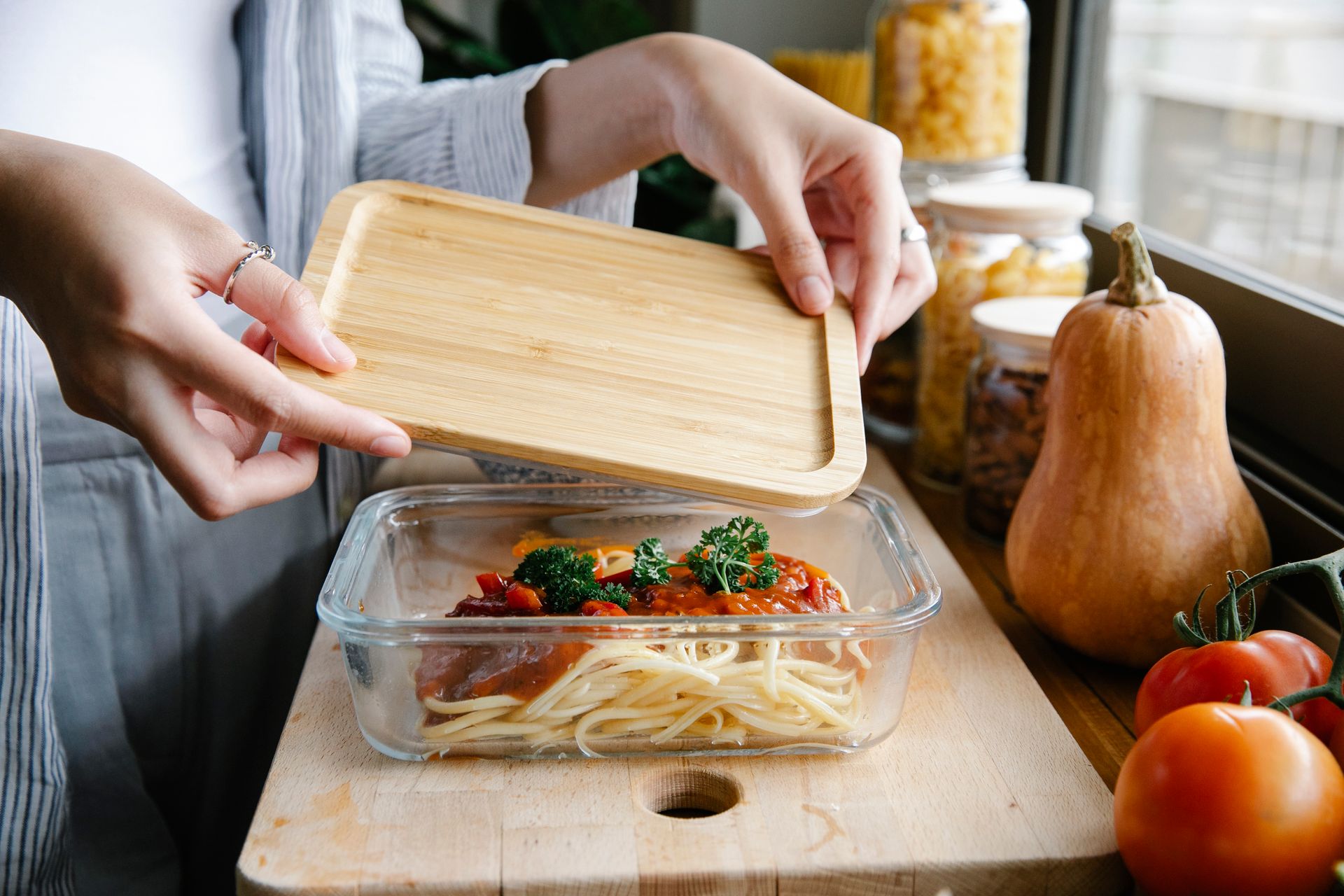 Menú semanal saludable: cómo planificar tus comidas aunque tengas poco tiempo persona organizando recipientes de comida preparada
