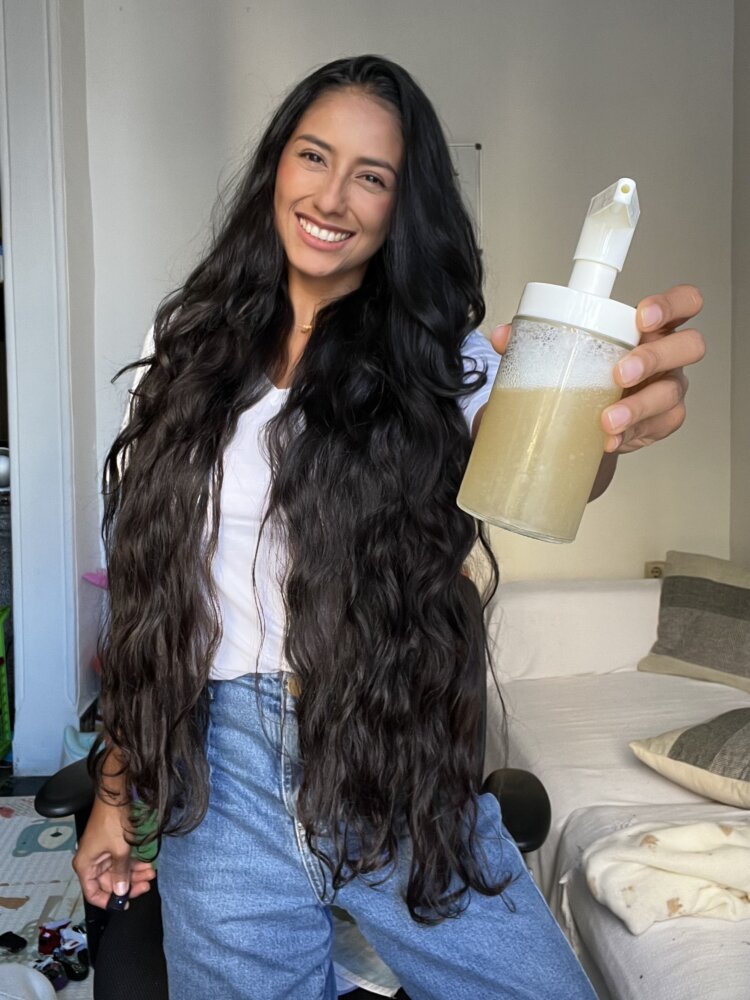 Romina mostrando un champú elaborado por ella 